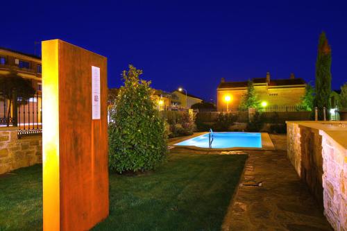 a swimming pool in a yard at night at Hotel El Juglar in Olite