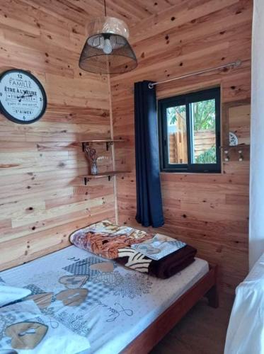 1 dormitorio con 1 cama en una cabaña de madera en Bungalow de la caz l'écho, en Cilaos