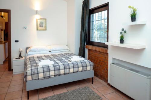 um pequeno quarto com uma cama e uma janela em Residence San Raffaele 1 em Milão