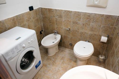 a bathroom with a washing machine and a toilet at Residence San Raffaele 1 in Milan