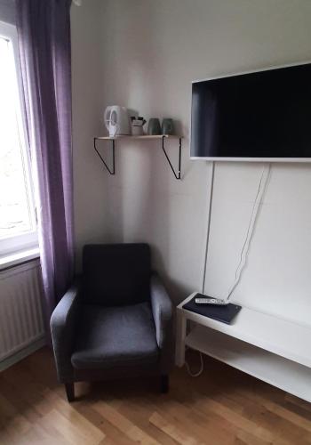 a living room with a chair and a flat screen tv at Breanäs Hotell in Immeln