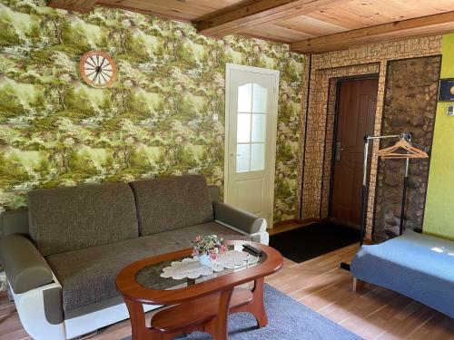 a living room with a couch and a table at Ezerzemes 2 in Kušneri