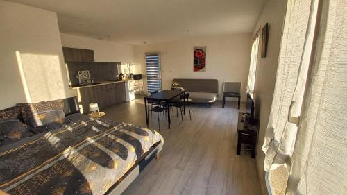 a bedroom with a bed and a table and a kitchen at Studio Pivoine avec terrasse a proximité de Metz in Metz
