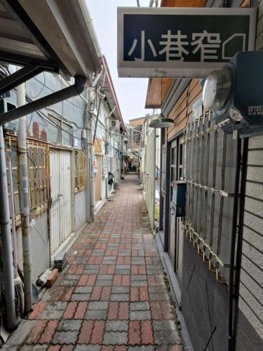 an alleyway in an asian city with a sign on a building at 小巷窄 in Tainan