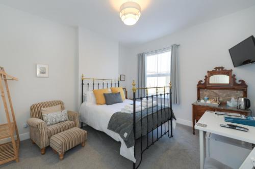 a bedroom with a bed and a chair at Borrowfield Lodge in Derby
