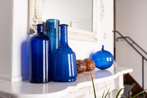 two blue bottles sitting on a table in front of a mirror at De Soeten Inval in Middelburg