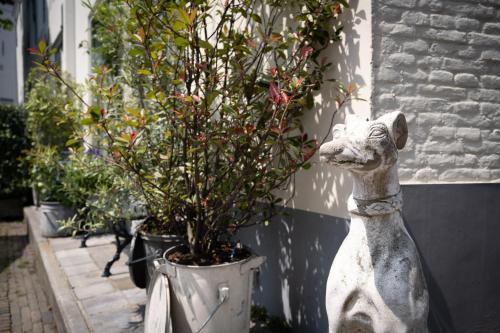 a statue of a dog next to a potted plant at De Soeten Inval in Middelburg