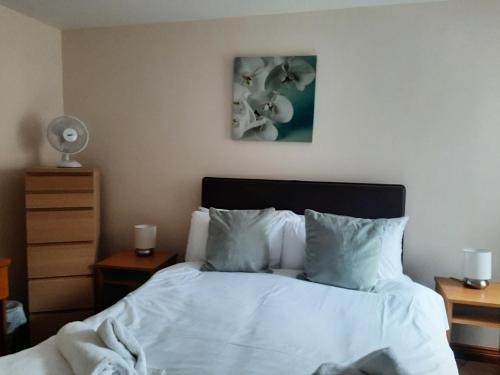 a bed with white sheets and pillows in a bedroom at Holly Lodge in Alnwick