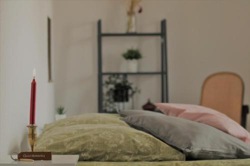 Un dormitorio con una cama con almohadas y una vela en Auberge de la Loue, en Vodable