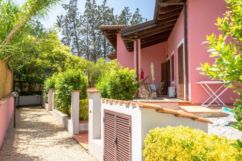 a pink house with a fence in front of it at Hotel Villa Rosa in Porto Azzurro