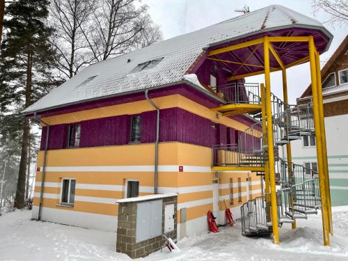 a house in the snow in front at Apartmán Riviera J1/1 in Lipno nad Vltavou