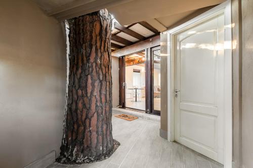 un albero al centro di una stanza con una porta di ELEGANTE VILLINO nel verde di Roma a Roma
