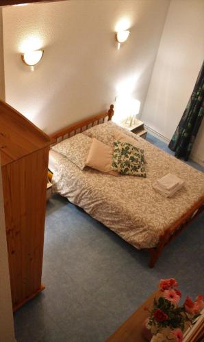 une chambre avec un lit avec deux oreillers dessus dans l'établissement Auberge de la Loue, à Vodable