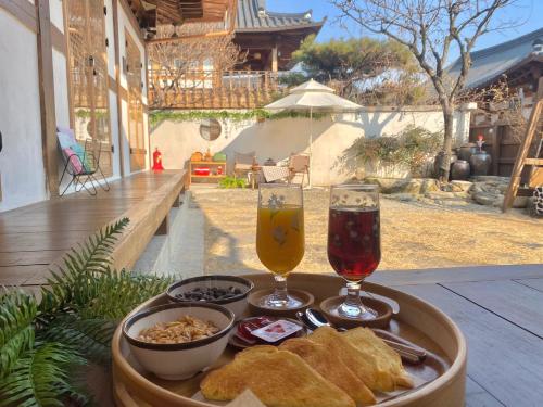 a tray with bread and two glasses of beer at Pungnam House in Jeonju