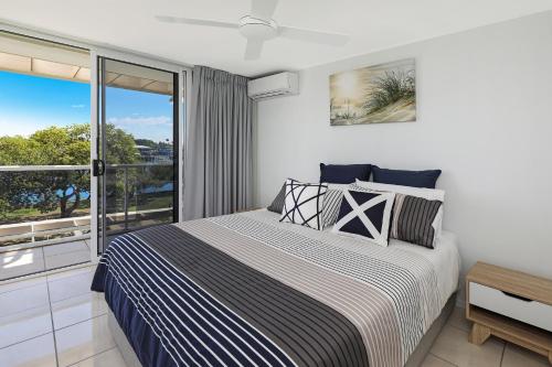 a bedroom with a bed and a balcony at Spinnaker Quays in Mooloolaba