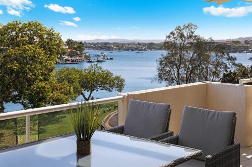 a balcony with a table and chairs and a view of the water at Spinnaker Quays in Mooloolaba