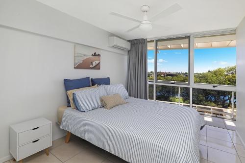 a bedroom with a bed and a large window at Spinnaker Quays in Mooloolaba