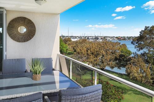 a balcony with a table and chairs and a view of the water at Spinnaker Quays in Mooloolaba