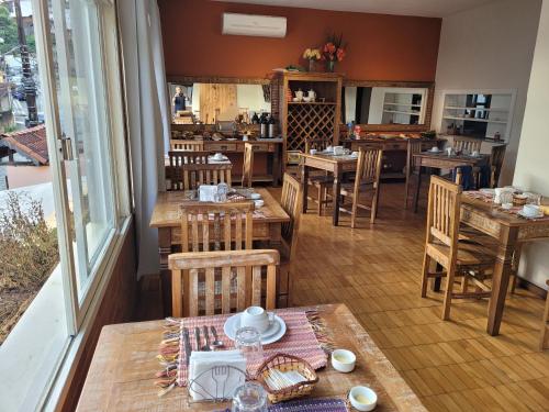 a restaurant with wooden tables and chairs and a dining room at Pousada Danitato e lavanderia in Bom Jardim