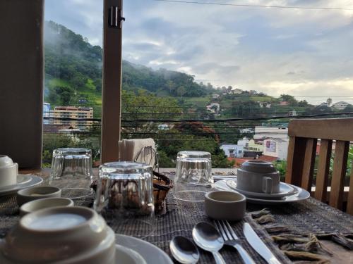 a table with plates and silverware on a table with a view at Pousada Danitato e lavanderia in Bom Jardim