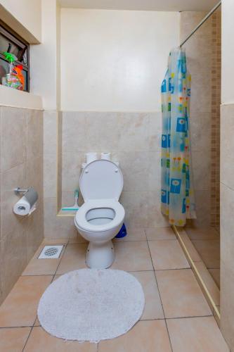 a bathroom with a toilet and a shower at Westpoint Suites by Senga in Nairobi