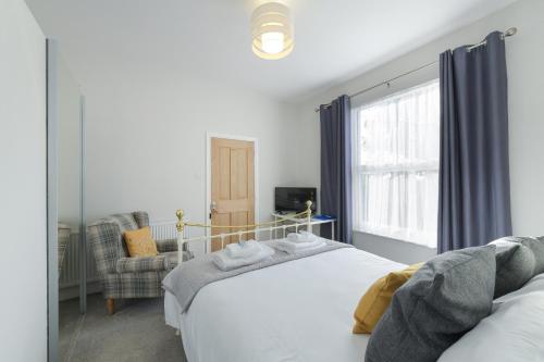 a bedroom with a large white bed and a window at Borrowfield Lodge in Derby