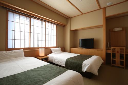 京都 嵐山温泉 花伝抄 - 共立リゾート -にあるベッド