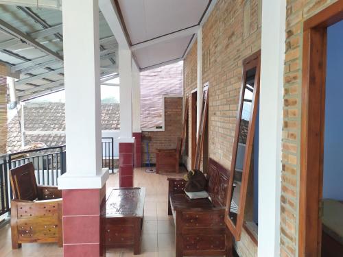 a hallway with tables and chairs and a brick wall at Homestay Syariah Mami Borobudur in Borobudur