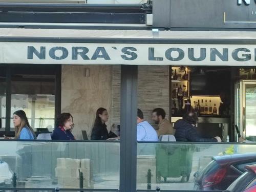 a group of people sitting outside of a restaurant at BEACHFRONT with Seaviews Apartment No56 Award Winner Unbeatable Location for Closeness to the Sea Ideal for Guests looking for Winter Spring and Autumn Breaks in Sunny Malta Also Ideal for Coastal Hikers in Mellieħa