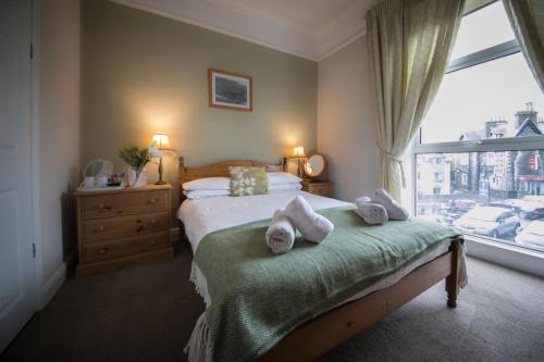a bedroom with a bed with towels on it at Lingmoor in Windermere