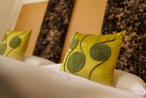 two yellow pillows sitting on top of a bed at Hotel Garni Toscanina - Adults Only in Bad Radkersburg