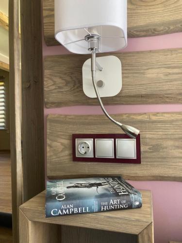 a lamp sitting on top of a table with a book at Vējavas in Svettsiyems