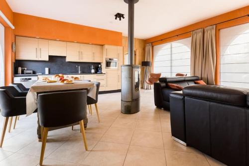 De Notelaar في Alveringem: مطبخ وغرفة معيشة مع طاولة وأريكة