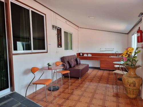a living room with a couch and a table and chairs at Baan Sabaijai Resort in That Phanom