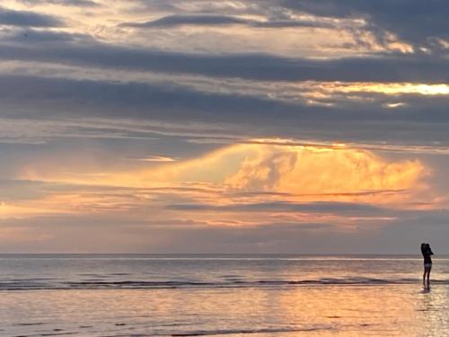 a person standing on the beach at sunset at Vējavas in Svettsiyems