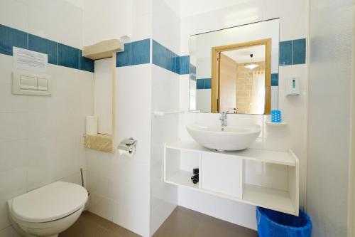 a white bathroom with a sink and a toilet at Camere a Sud in Alliste