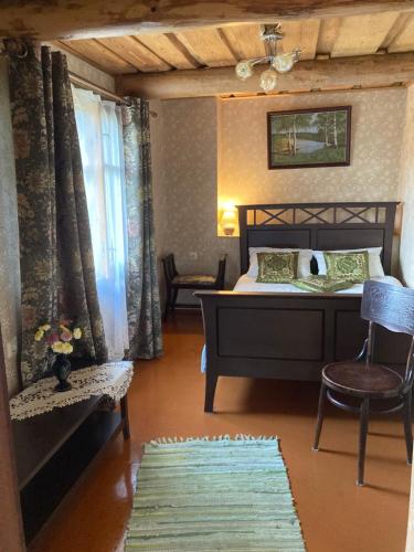 a bedroom with a bed and a chair and a window at Vējavas in Svettsiyems