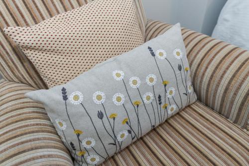 a pillow with flowers on it sitting on a couch at Borrowfield Lodge in Derby