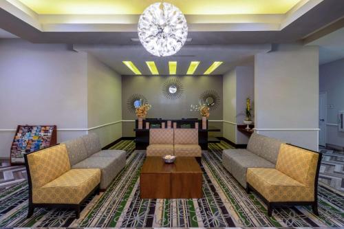 a lobby with couches and a table and a chandelier at La Quinta by Wyndham Houston NW Beltway8/WestRD in Houston