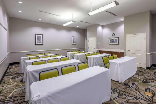 a conference room with white tables and yellow chairs at La Quinta by Wyndham Houston NW Beltway8/WestRD in Houston