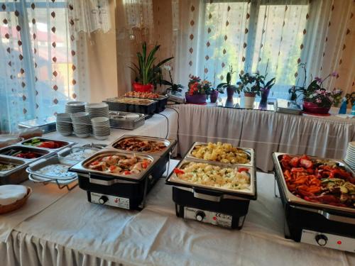a buffet line with many different types of food at HOTEL CARPATHIA in Remeţi