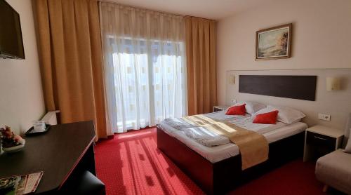 a hotel room with a bed and a large window at HOTEL CARPATHIA in Remeţi
