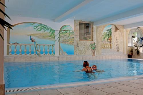 zwei Personen in einem Pool in einem Hotel in der Unterkunft Alpenhotel Regina in Nauders