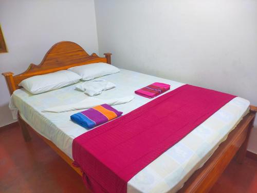 a bed with two towels and two pillows on it at Deer Garden Guest in Polonnaruwa