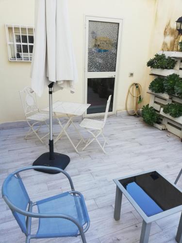 a room with a blue chair and a table and chairs at La Terrazza della Nonna in Palermo