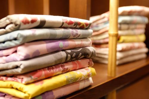 京都市にある京都 嵐山温泉 花伝抄 - 共立リゾート -の棚に腰掛けた折りたたみ式シャツ