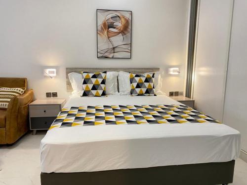 1 dormitorio con 1 cama grande con manta a cuadros en Résidence Cap Sud en Dakar