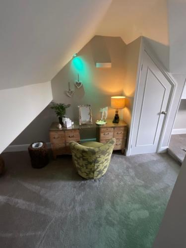 a attic room with a chair and a desk and a door at Windermere Boutique Hotel Spa Suites & Hot Tubs in Windermere