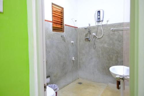a bathroom with a shower and a sink at Thilina Homestay in Sigiriya