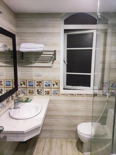 a bathroom with a sink and a toilet and a window at Victory Hotel, số 7, Vương Thúc Mậu, Tp Vinh in Vinh